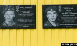 Memorial plaques on the school in the village of Kuratovo, where Semyon (left) and Aleksandr Tutrinov studied.